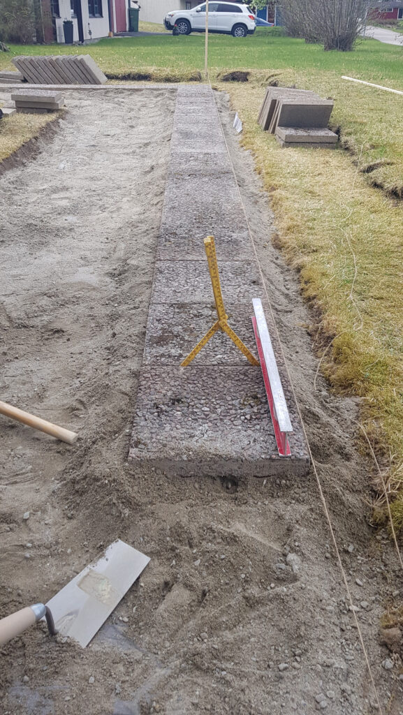 gjuter betongplattor med laseravvägning gjuter betongplattor med laseravvägning framför ett hus